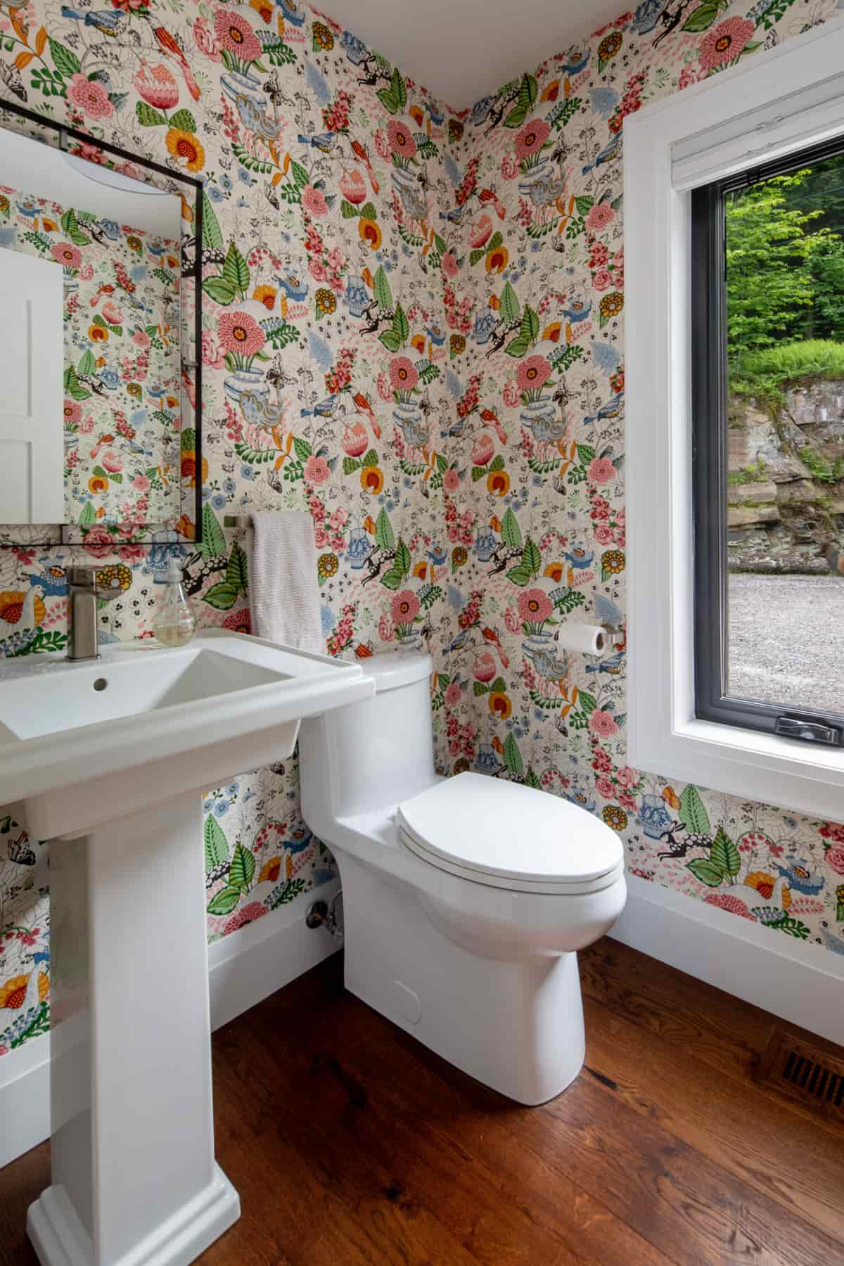 Elegant bathroom with floral wallpaper and a toilet, situated in Lake Muskoka, crafted by Ballantyne Builds.