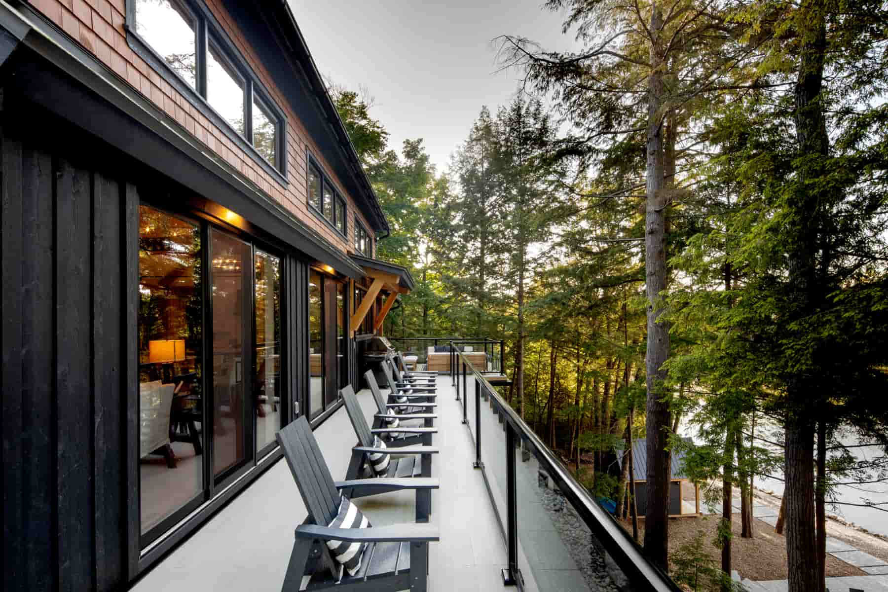 A picturesque deck featuring chairs, offering a stunning view of Lake Muskoka, highlighting Ballantyne Builds' design.