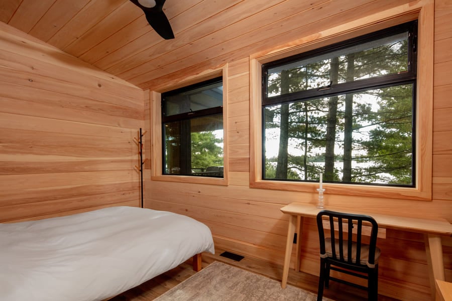 bedroom with large windows and wooden walls | Ballantyne Builds