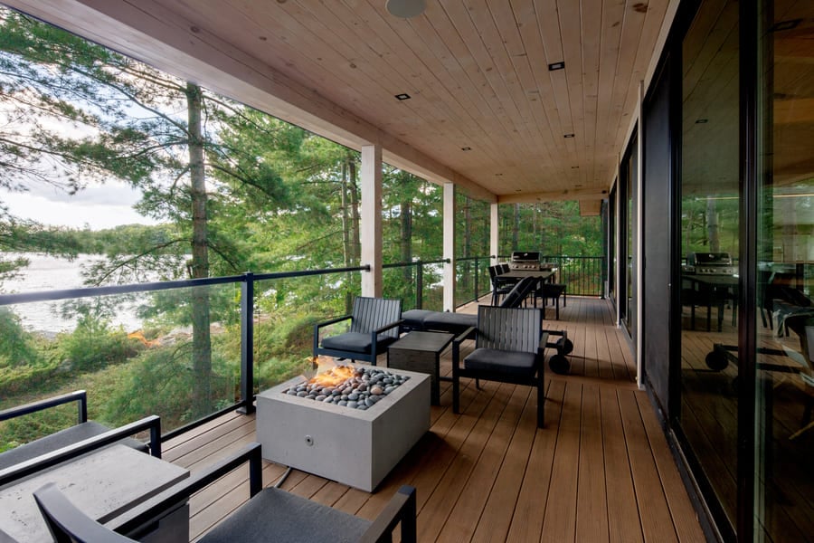 outside deck with fireplace overlooking lake trout | Ballantyne Builds